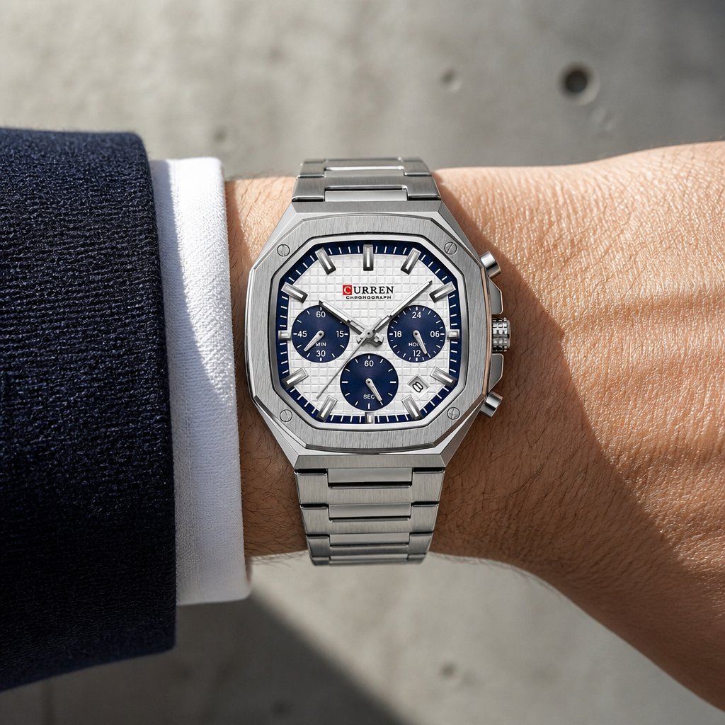 Montre octogonale argent à compteurs bleus portée au poignet sous une manchette de chemise