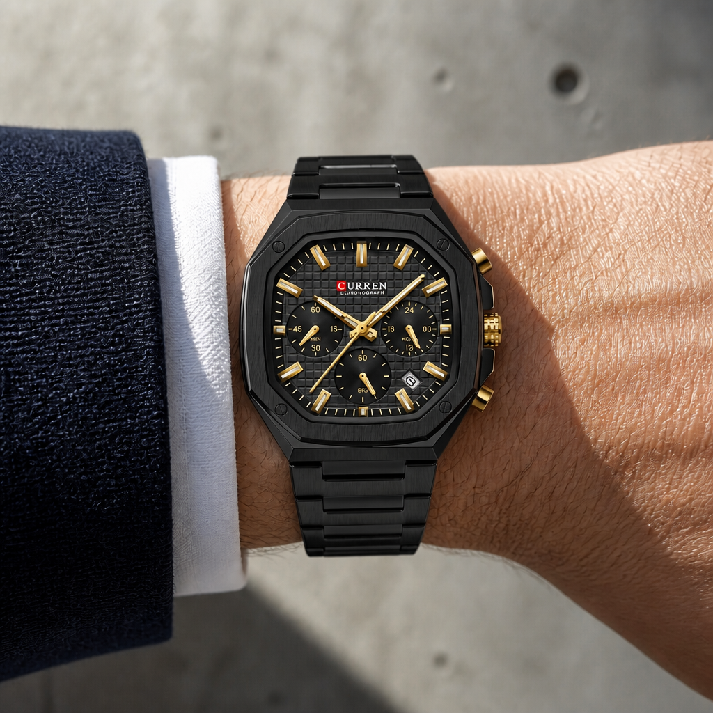 Montre octogonale noire et dorée portée au poignet