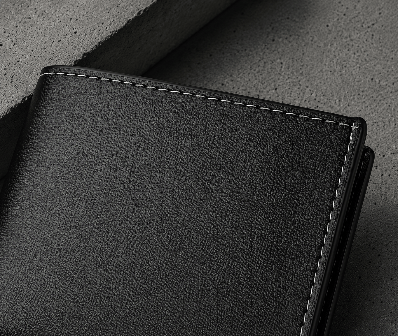 Detail des coutures contrastees blanches sur similicuir lisse du portefeuille homme moderne noir