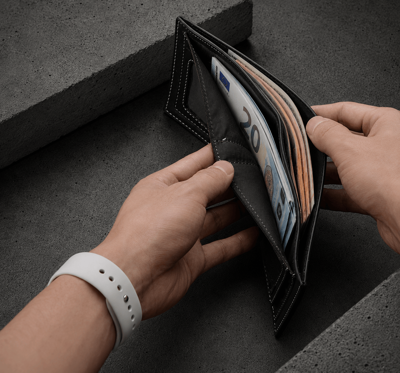 Portefeuille homme moderne noir ouvert montrant le double rangement billets euros