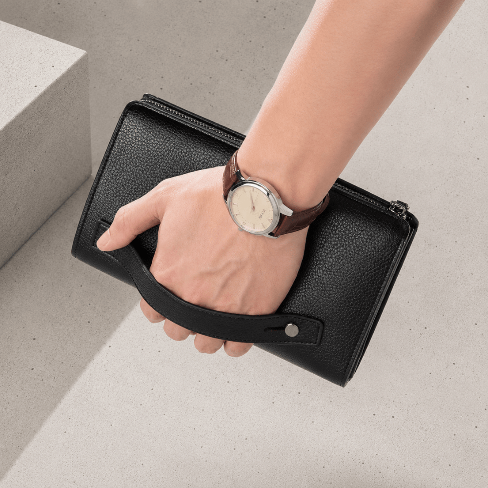 Portefeuille homme noir tenu par la dragonne au poignet