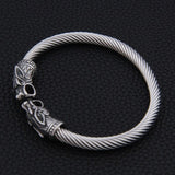 Bracelet jonc homme loup argent posé sur une table en cuir