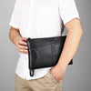Pochette en cuir noir portée par un homme