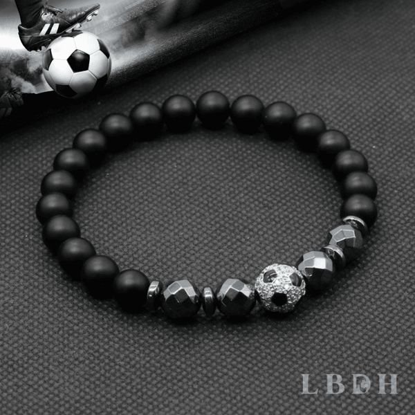 bracelet hématite perles et ballon foot soccer euro 2021 noir et argent mis en scène avec ballon au pied