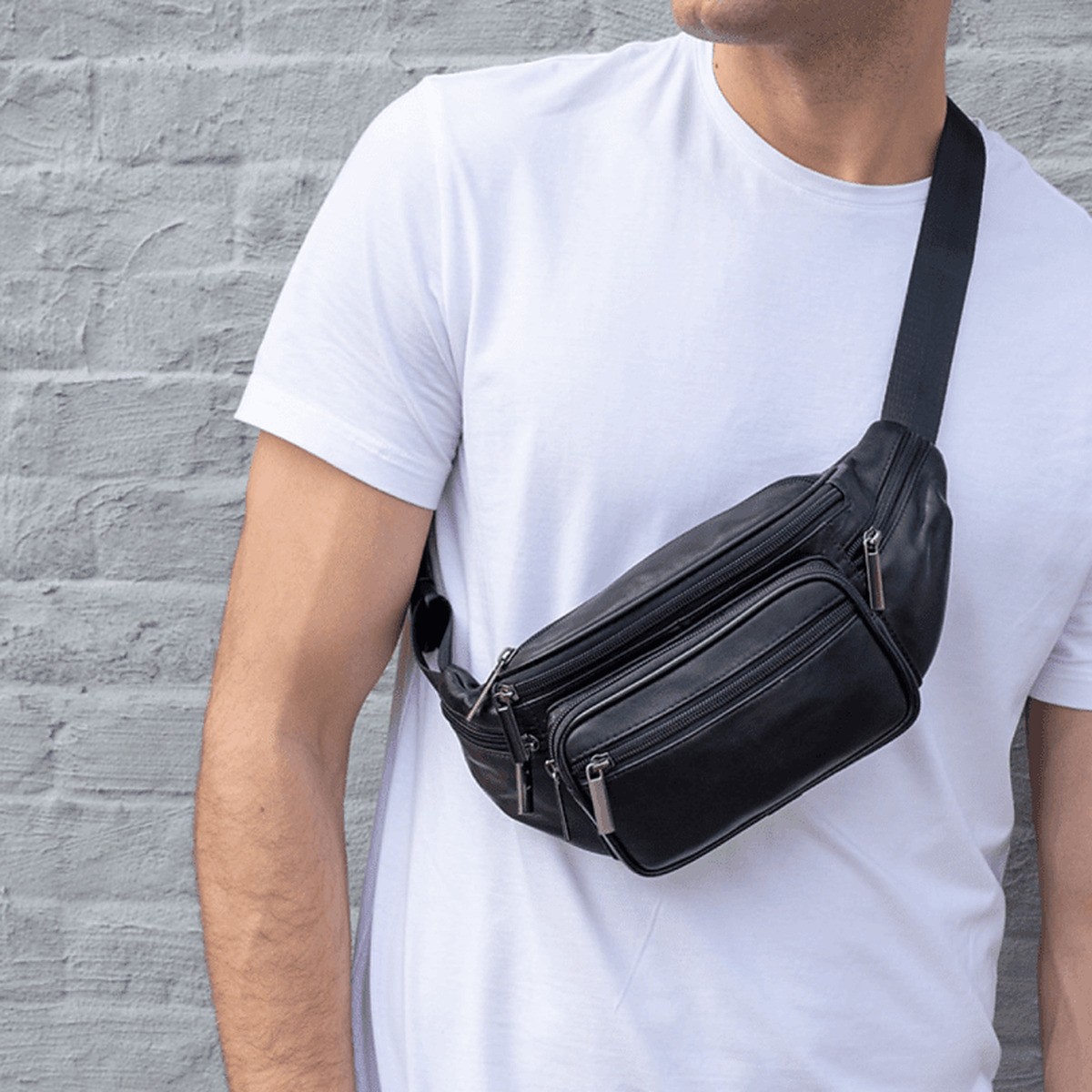 Homme portant le sac banane en cuir noir en bandoulière sur le torse
