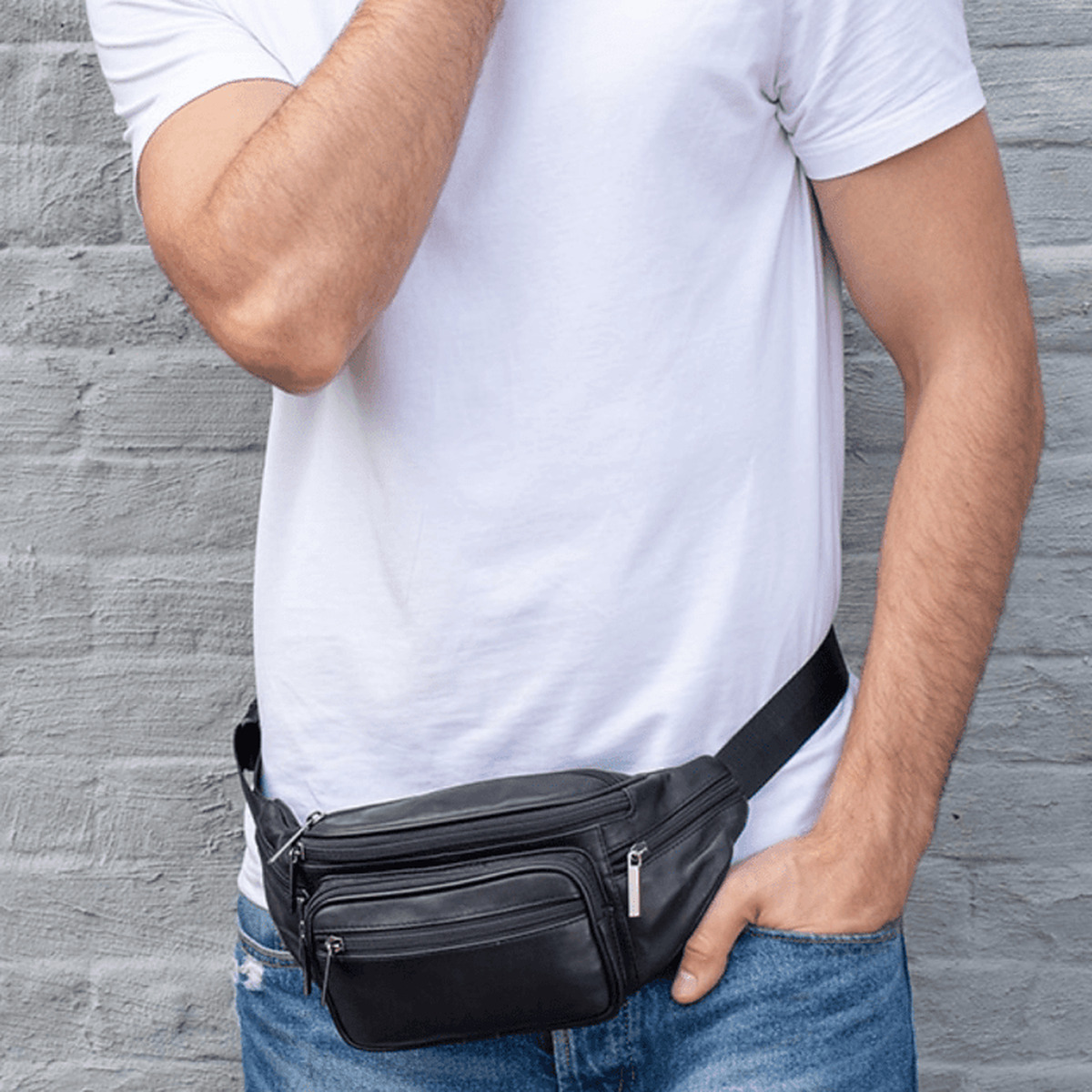 Sac banane en cuir noir porté à la taille avec un jean